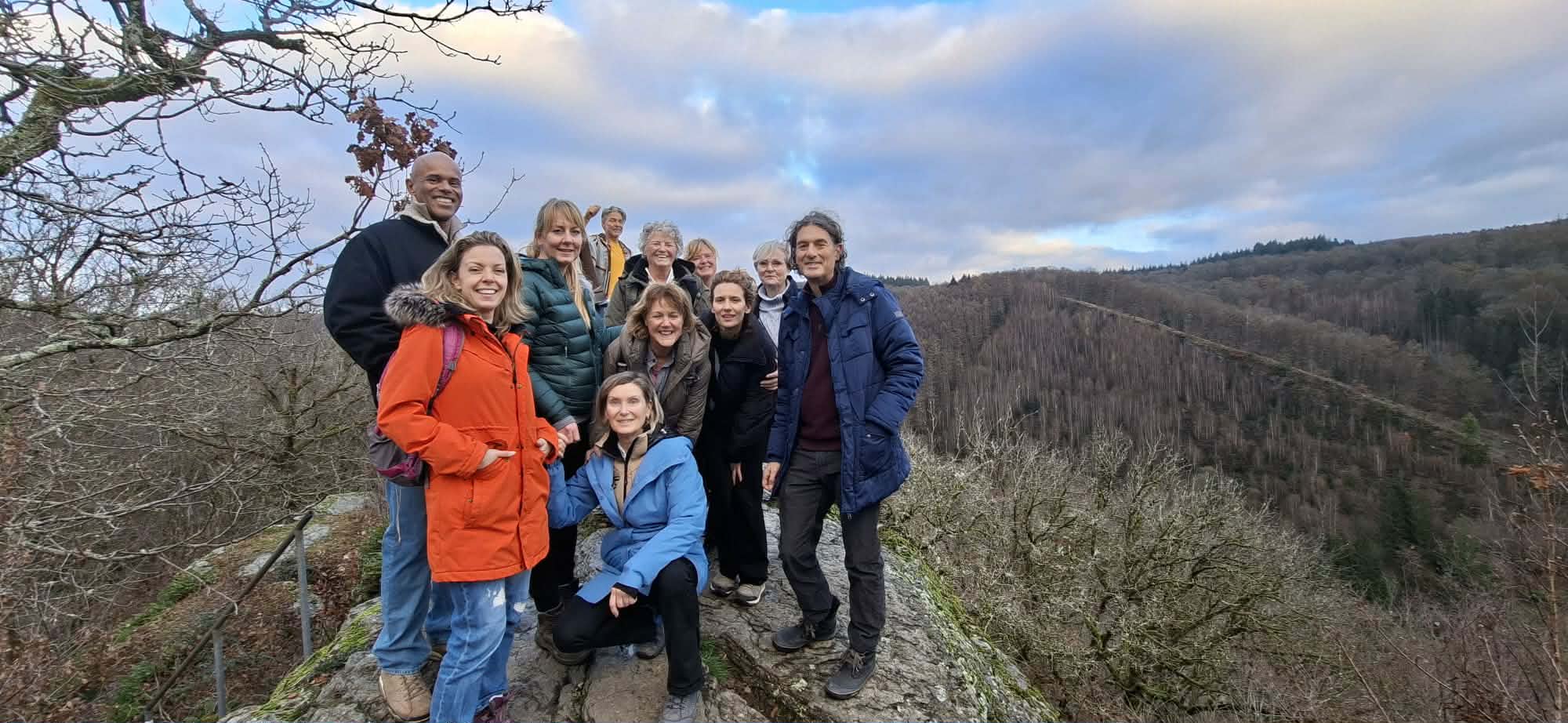 Groep deelnemers tijdens een retreat op een uitkijkpunt in de Ardennen