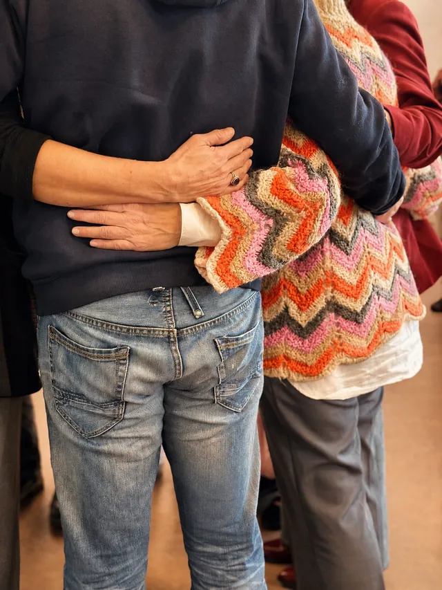 Twee deelnemers ondersteunen elkaar tijdens een workshop familieopstellingen